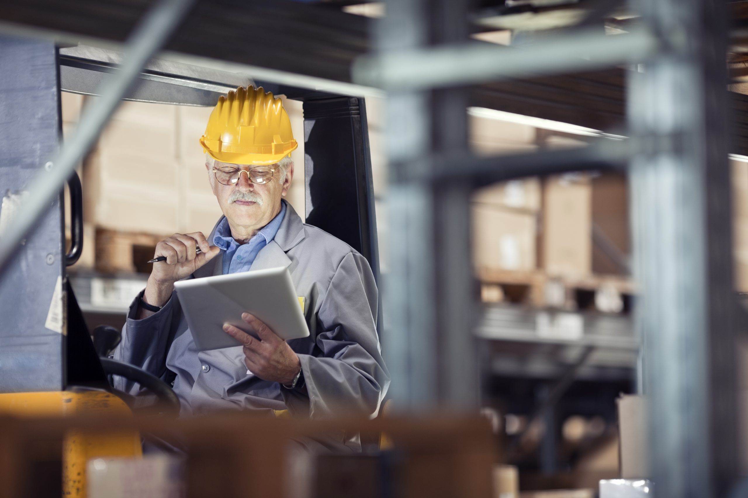 forklift operator at warehouse using digital tablet